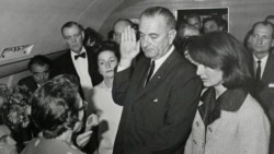 პრეზიდენტ კენედის მკვლელობიდან რამდენიმე საათში, ვიცე-პრეზიდენტი ჯონსინი თვითმფრინავის ბორტზე ფიცს დებს.