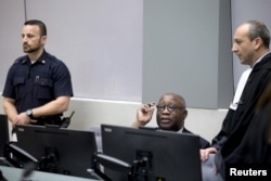 FILE - Former Ivory Coast President Laurent Gbagbo, center, and his lawyer Emmanuel Altit, right, wait for the start of the trial at the International Criminal Court in The Hague, Netherlands, Jan. 28, 2016.