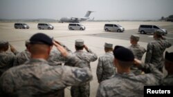 U.S. soldiers salute vehicles transporting the remains of 55 U.S. soldiers who were killed in the Korean War at Osan Air Base in Pyeongtaek, South Korea, July 27, 2018.