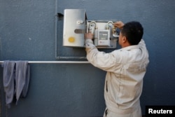 A worker installs a gas meter in Xiaozhangwan village at the outskirts of Beijing, China, Nov. 15, 2017.
