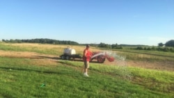 Danny Filsinger, suami Supadmi, menyirami rumput dengan semprotan air.