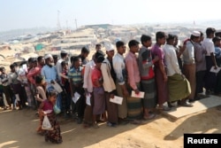 FILE - Rohingya refugees stand in a queue to collect aid supplies in Kutupalong refugee camp in Cox's Bazar, Bangladesh, Jan. 21, 2018.