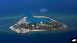 FILE - The Vietnamese-claimed Southwest Cay island in the Spratly island group is seen from a Philippine Air Force C-130 transport plane during the visit to the Philippine-claimed Thitu Island by Defense Secretary Delfin Lorenzana.