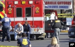 Emergency personnel work at the scene where Rep. Gabrielle Giffords, D-Ariz., and others were shot outside a Safeway grocery store in Tucson, Ariz., Jan. 8, 2011.