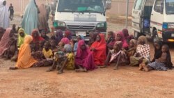 FILE - Women and children who were kidnapped in the northwestern state of Zamfara, sit after being rescued by the Nigerian security agents in Zamfara, Nigeria, October 7, 2021.