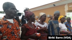 Des bénéficiaires ayant reçu leur kit composé d'un téléphone portable. (VOA/ Siriki Barro)