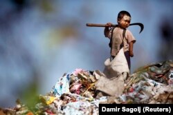An illegal immigrant boy from Myanmar collects plastic at a rubbish dump near Mae Sot December 22, 2009.
