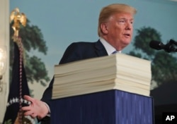 President Donald Trump speaks in the Diplomatic Room of the White House in Washington, March 23, 2018, about the $1.3 trillion spending bill.