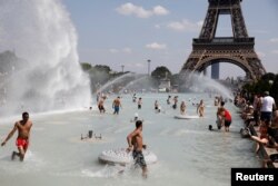 Banyak orang menyejukkan diri dengan bermain air di Trocadero, seberang Menara Eiffel, Paris saat gelombang panas menghantam sebagian besar negara tersebut, 25 Juni 2019. (Foto: dok).