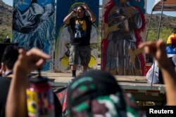 FILE - Nataanii Means performs during a rally at the Oak Flat Campground in the Tonto National Forest near Superior, Ariz., May 30, 2015.