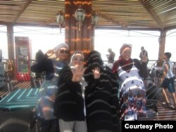 Sherien Fadel and friends display the rival hand signs of pro and anti government Egyptians. (Courtesy Sherien Fadel)