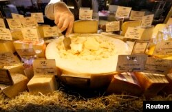 A worker arranges cheese for sale at a grocery store in St. Petersburg, Russia, Aug.11, 2014.