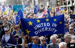 FILE - Anti Brexit campaigners carry flags and banners as they march towards Britain's parliament in London, March 25, 2017.