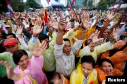 FILE - People raise their arms as they gather during a protest at Freedom Park in central Phnom Penh December 17, 2013.