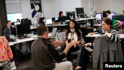 FILE - Facebook employees are seen gathered in their workspace for a discussion at Facebook headquarters in Menlo Park, California, Jan. 11, 2012. The social media giant recently made public its internal editorial guidelines, in the latest attempt to fight charges of political bias.
