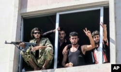 FILE - Free Syrian Army fighters gesture in Jarablus, Syria, Aug. 31, 2016.
