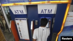 Seorang pria menggunakan ATM untuk mengambil uang di Yangon, Myanmar (foto: dok).