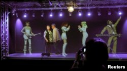 A couple performs with a "virtual ABBA band" during a media preview at the new "ABBA - The Museum" in Stockholm, May 6, 2013.