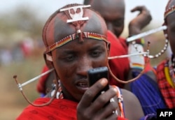 Orang suku Maasai menggunakan ponsel di desa Mbirukani di Kajiado, Kenya, Juni 2015.