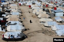 A woman walks through al-Hol displacement camp in Syria April 2, 2019.