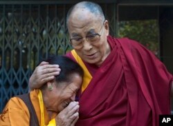 FILE - An elderly Tibetan woman, who was among those waiting to receive the Dalai Lama, gets emotional as the spiritual leader greets devotees upon arrival at the Institute of Buddhist Dialectics near Dharmsala, India.