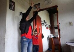 Marlene Beltran, 14, left, and her brother Felipe Beltran, 5, exercise during a gym class broadcast through Bacata Stereo radio station during the lockdown in Funza, Colombia, Wednesday, May 13, 2020.