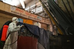 ក្រុមការងារដែលស្ថិតក្នុងសម្លៀកបំពាក់ការពារខ្លួនពីមេរោគ កំពុងបាញ់ថ្នាំសម្លាប់មេរោគនៅក្នុងផ្សារអូរឬស្សី បន្ទាប់ពីមានករណីឆ្លងក្នុងចំណោមអាជីវករនៅផ្សារនេះ នៅរាជធានីភ្នំពេញ កាលពីថ្ងៃទី ៤ ខែមេសា ឆ្នាំ ២០២១។