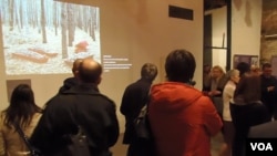 参观者观看关于一处集体墓葬地的图片。（美国之音白桦拍摄）