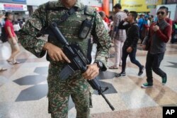 FILE - Malaysia military personnel patrol KL Sentral train station in Kuala Lumpur, Malaysia, July 7, 2016. The nation was on high alert after an Islamic State attack the week before.
