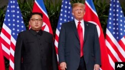 FILE - U.S. President Donald Trump, right, meets with North Korean leader Kim Jong Un on Sentosa Island, in Singapore, June. 12, 2018. North Korea warned Friday it could revive a state policy aimed at strengthening its nuclear arsenal if the United States