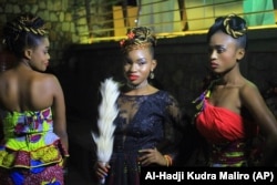 In this photo taken Saturday Dec. 23, 2017, Models pose for a photograph back stage before a fashion show in Beni Eastern Congo .