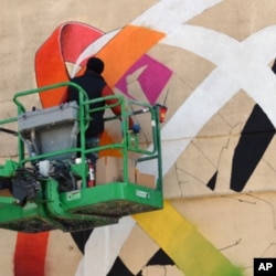 Ukrainian artist Vladimir Manzhos at work on his mural.