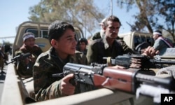 Newly recruited Shi'ite fighters, known as Houthis, ride on the back of a truck as they take part during a gathering aimed at mobilizing more fighters into battlefronts to fight pro-government forces in several Yemeni cities, in Sanaa, Yemen, Jan. 12, 2017.