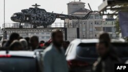 Palestinians gather near the broken helicopter of late Palestinian President Yasser Arafat placed on top of a structure in Gaza City, Nov. 11, 2018, as they mark the 14th anniversary of Arafat's death.
