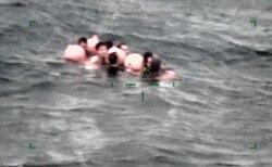 Anggota awak kapal nelayan China yang terbalik di Pulau Ishigaki, prefektur Okinawa, Jepang selatan pada hari Selasa, 2 Maret 2021, tertangkap oleh kamera yang dipasang pada pesawat dan dirilis oleh Markas Penjaga Pantai Regional Jepang ke-11. (Foto: Penjaga Pantai Regional Jepang ke-11 via AP).