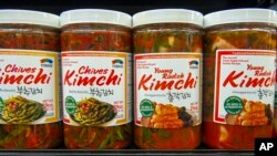 FILE - Different flavors of Korean Kimchi are displayed in a cooler at the Super H Mart Asian grocery in Fairfax, Virginia, July 20, 2015. Classic Korean food items are showing up with more frequency on American menus and grocery shelves.