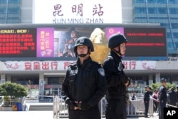 FILE - Armed police stand guard at China's Kunming railway station in Yunnan province, March 2, 2014. A day earlier, assailants slashed scores of people there, ultimately killing 31.