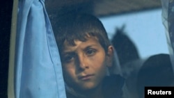 A child evacuated from a cargo ship looks through a bus window, in Ierapetra, on the island of Crete, Nov. 27, 2014.