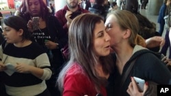 FILE- In this Jan. 29, 2017 file photo, Vahideh Rasekhi, an Iranian doctoral student at Stony Brook University, greets friends and family as she is released from detention at John F. Kennedy International Airport in New York.