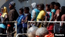 Migrants wait to disembark from the Italian Navy vessel Vega at the Reggio Calabria harbor, southern Italy, May 29, 2016.