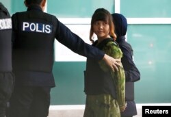 Vietnamese Doan Thi Huong who is on trial for the killing of Kim Jong Nam, the estranged half-brother of North Korea's leader, is escorted as she arrives at the Department of Chemistry in Petaling Jaya, near Kuala Lumpur, Malaysia October 9, 2017.