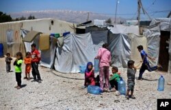 Syrian refugee children play outside their family tents at a Syrian refugee camp in the town of Bar Elias, in Lebanon's Bekaa Valley, April 23, 2018.