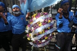 FILE - Members of Indonesian Workers Union pray outside the Ministry of Energy and Natural Resources in Jakarta, Indonesia during a solidarity rally for the victims of the collapsed mine at a Freeport mining area in Papua province, May 21, 2013.