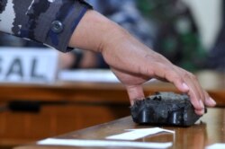 Personel TNI AL membawa puing-puing yang diyakini berasal dari kapal selam TNI AL KRI Nanggala-402 yang hilang, ditampilkan saat jumpa pers di Bandara I Gusti Ngurah Rai, Bali, 24 April 2021. (Foto: Antara/Fikri Yusuf via REUTERS)