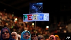 FILE - A placard reading 'Peace' is held by a woman during an Islamic peace conference at Wembley Arena in north-west London, Saturday, Sept. 24, 2011.