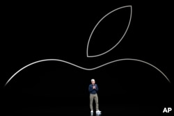 FILE- Apple CEO Tim Cook discusses the new Apple iPhones and other products at the Steve Jobs Theater during an event to announce new products in Cupertino, California, Sept. 12, 2018.