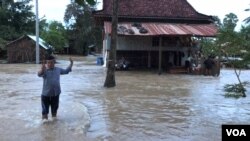 ភឿន ពិសិធ​ វ័យ​៣២ឆ្នាំ​ ដើរ​ចេញពីផ្ទះ​ ដែលកំពុងរងការជន់​លិចនៅក្នុង​ឃុំ​ត្រពាំង​ព្រីង​ ស្រុក​ទឹក​ឈូ​ ខេត្តកំពត​ ថ្ងៃទី​១១ ខែ​សីហា​ ឆ្នាំ​២០១៩។ (ហ៊ុល រស្មី​/VOA)