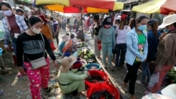 រូបឯកសារ៖ កម្មករ​រោងចក្រពាក់ម៉ាស់ការពារនិងនាំ​គ្នា​ដើរ​ទិញ​ត្រីសាច់​នៅ​ក្នុង​ផ្សារ​ត្រី​មួយ ក្រោយ​ពី​ចប់​ម៉ោង​ការងារ ភ្នំពេញ ថ្ងៃ​សុក្រ ទី​២០ ខែមីនា ឆ្នាំ​២០២០។ (AP Photo/Heng Sinith)