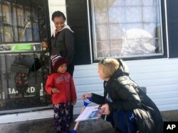 Doug Jones' campaign volunteer Dana Ellis, right, talks to Ebonique Jiles and her son, Dec. 9, 2017, in Birmingham, Ala., about voting on Tuesday's senatorial election.