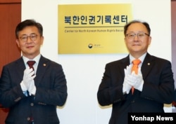 홍용표 한국 통일부 장관(왼쪽)과 유호열 민주평통 수석부의장이 28일 서울에서 열린 북한인권기록센터 개소식에서 현판 제막을 마친 뒤 기념촬영을 하고 있다.